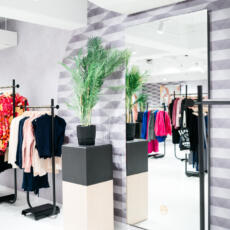 Verzilverde passpiegel tegen de wand in een kledingwinkel