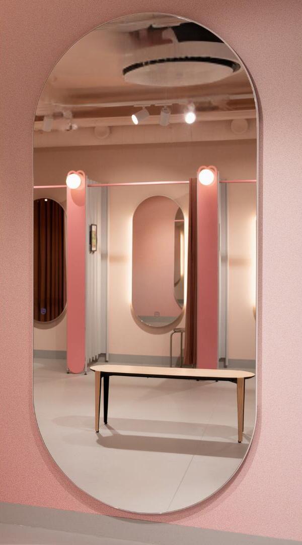 Dubbele boogspiegel, hangend aan de muur in een pashokje