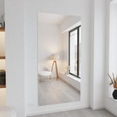 Verzilverde blanke designspiegel aan de muur in modern interieur