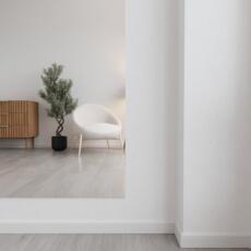 Verzilverde blanke hangspiegel aan de muur in licht interieur