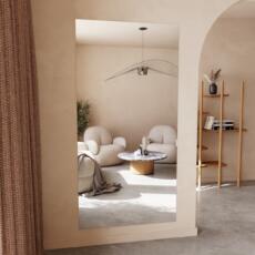 Plat poly geslepen verzilverde spiegel aan de muur in lichte ruimte