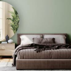 Halfronde bronzen spiegel in een moderne slaapkamer