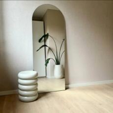 Hoge boogspiegel staand tegen de muur.