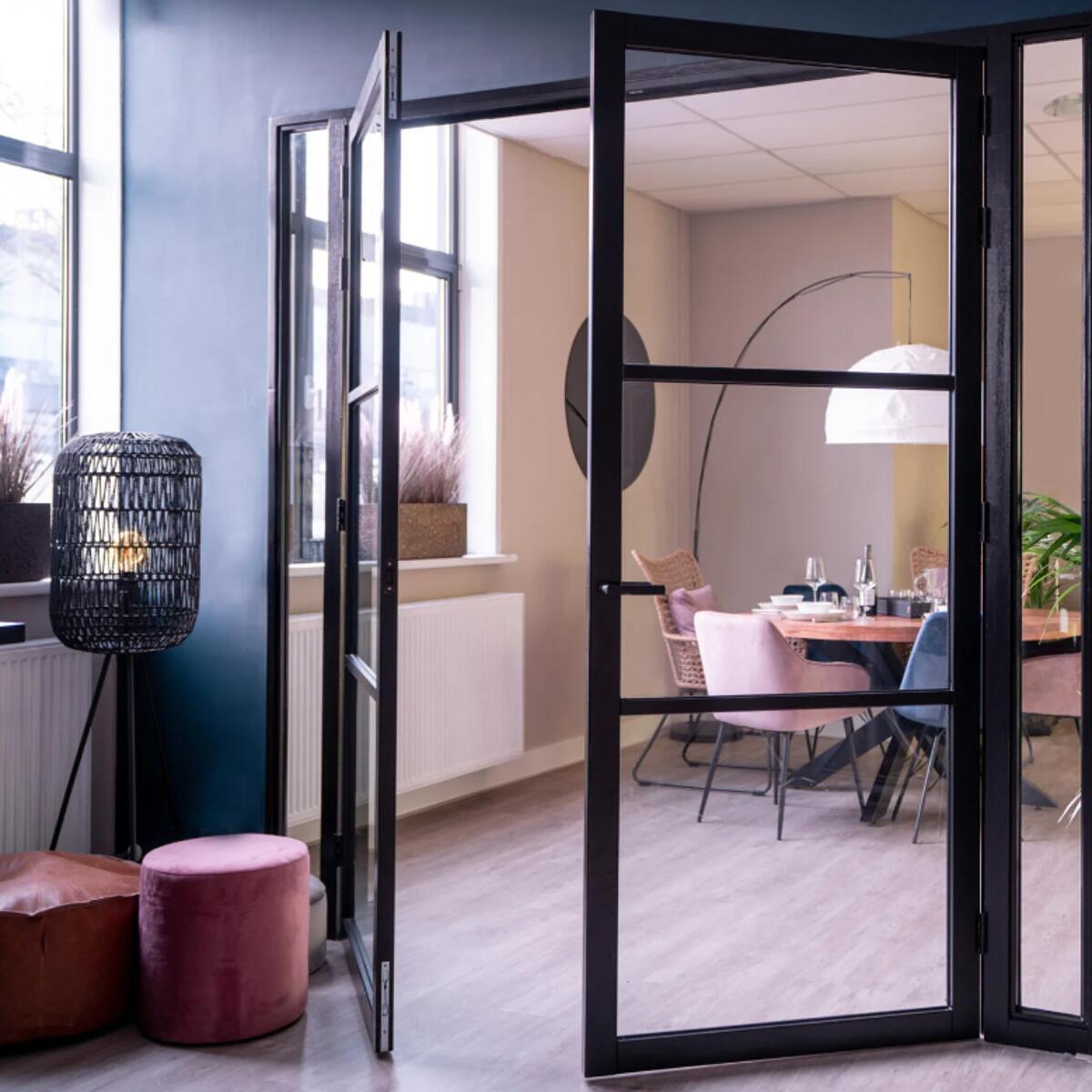 Deur met veiligheidsglas en zwart stalen frame in modern interieur