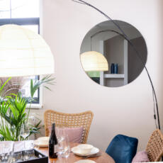 Grijs gekleurde ronde spiegel in een eetkamer