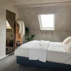 Brons gekleurde spiegel aan de muur geplakt in een slaapkamer