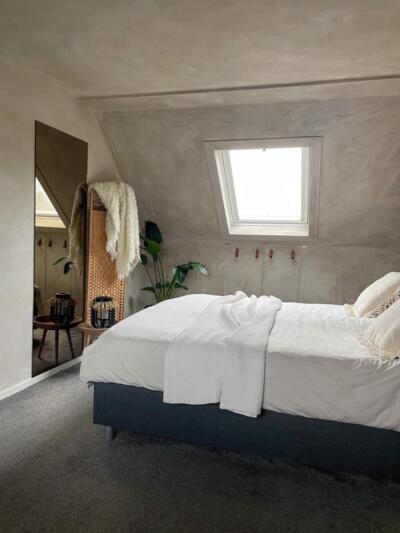 Brons gekleurde spiegel aan de muur geplakt in een slaapkamer