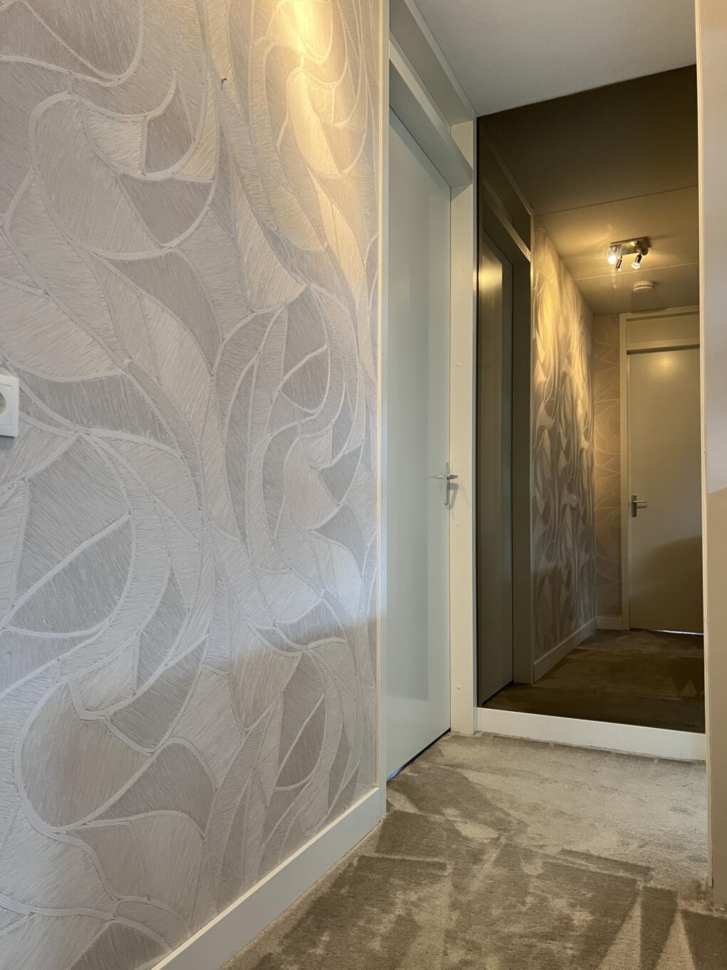 Wandspiegel brons gekleurd in een gang