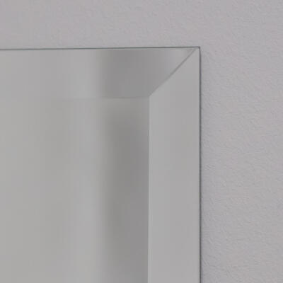 Facet geslepen spiegel met de rand van dichtbij te zien. De spiegel is een standaard verzilverde kleur