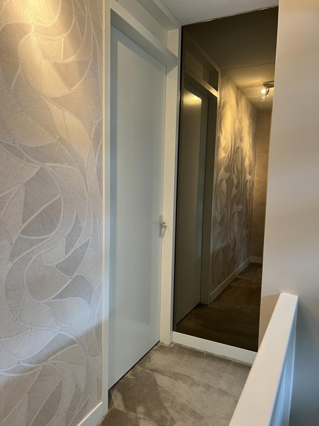 Hoge spiegel op maat in de kleur brons hangend aan de wand