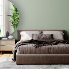 Een halfronde verzilverde spiegel in een slaapkamer