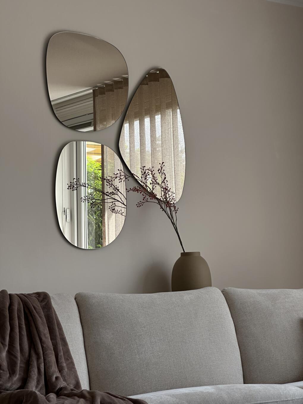 Organische spiegels aan de woonkamermuur geplakt, brons gekleurd